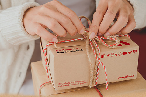 Frauenhände, die Paket schnüren